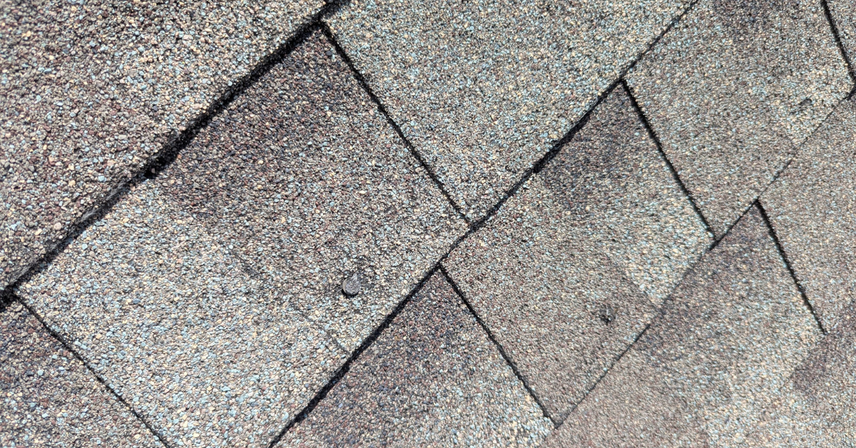 Residential roof replacement by DFW Roofers in Plano, Texas, highlighting damage in the shingles